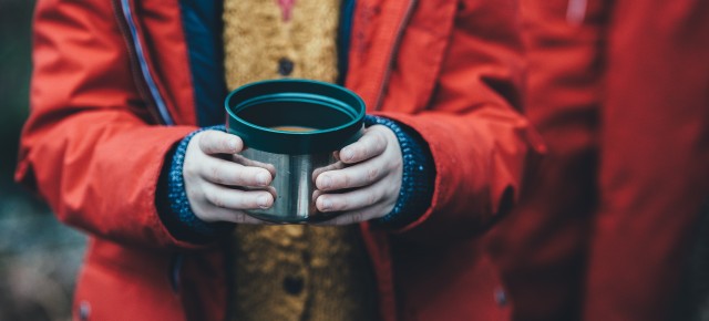 shallow focus photography of person holding soup cup